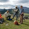 Five people on top of a mountain having a conversation